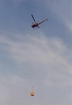 Helicopter using long line to carry straw.