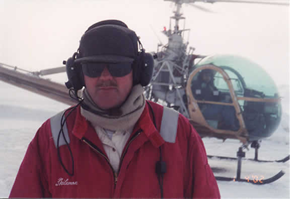 Pilot infront of helicopter.